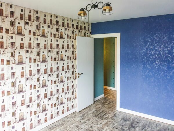 Fertig tapezierte und gestrichene Wand in einem modernisierten Zimmer in Berlin.